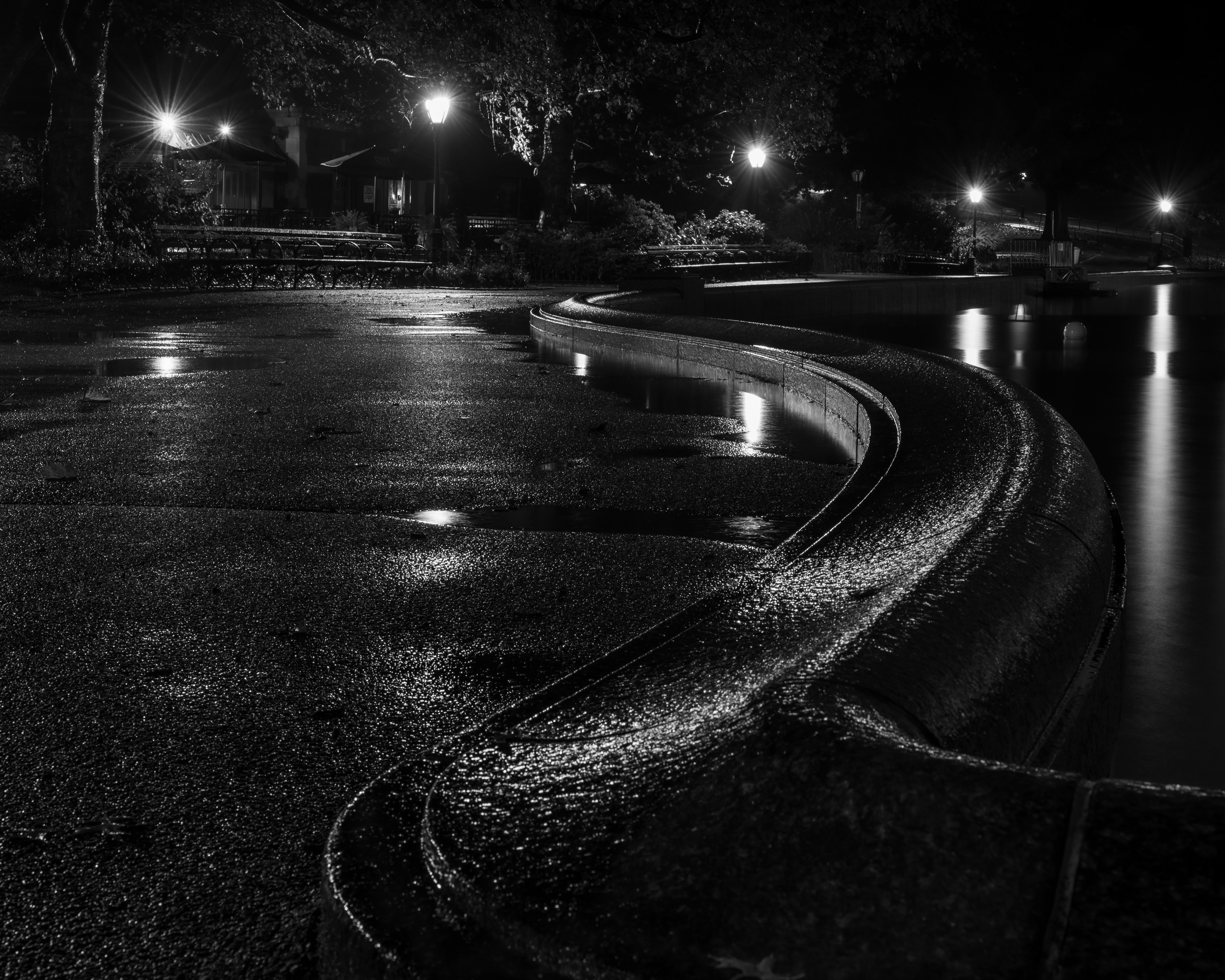 Dark, reflective night with wet streets under soft lighting